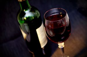 Glass of red wine with bottle